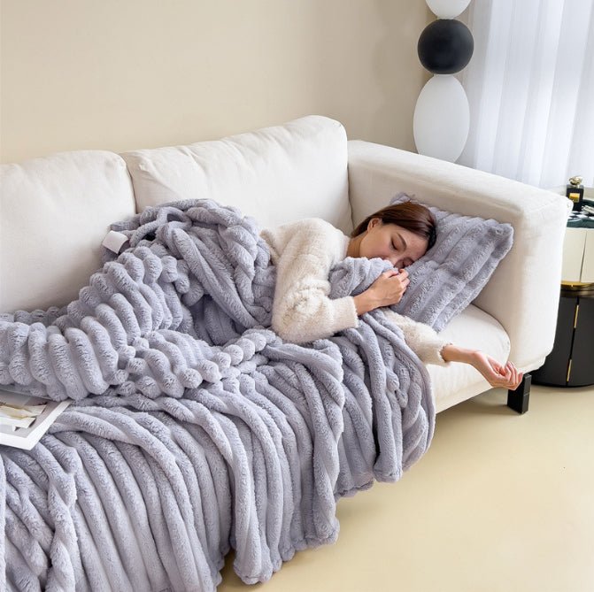 Purple ribbed throw in a soft lilac grey, draped over a sofa