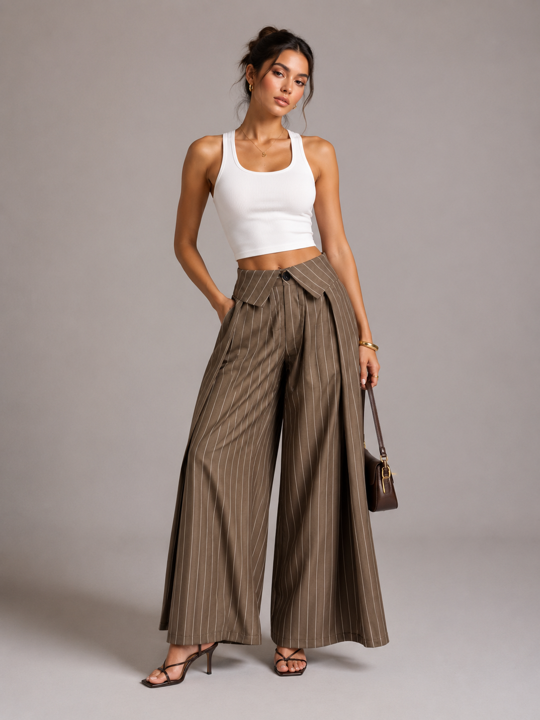 Brown pinstripe wide-leg trousers with fold-over waistband, front view on model in white tank top