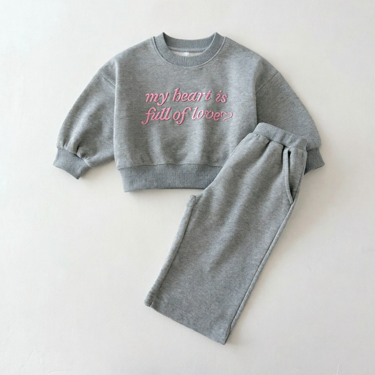 Grijs setje met sweater met roze geborduurde tekst en wijde broek