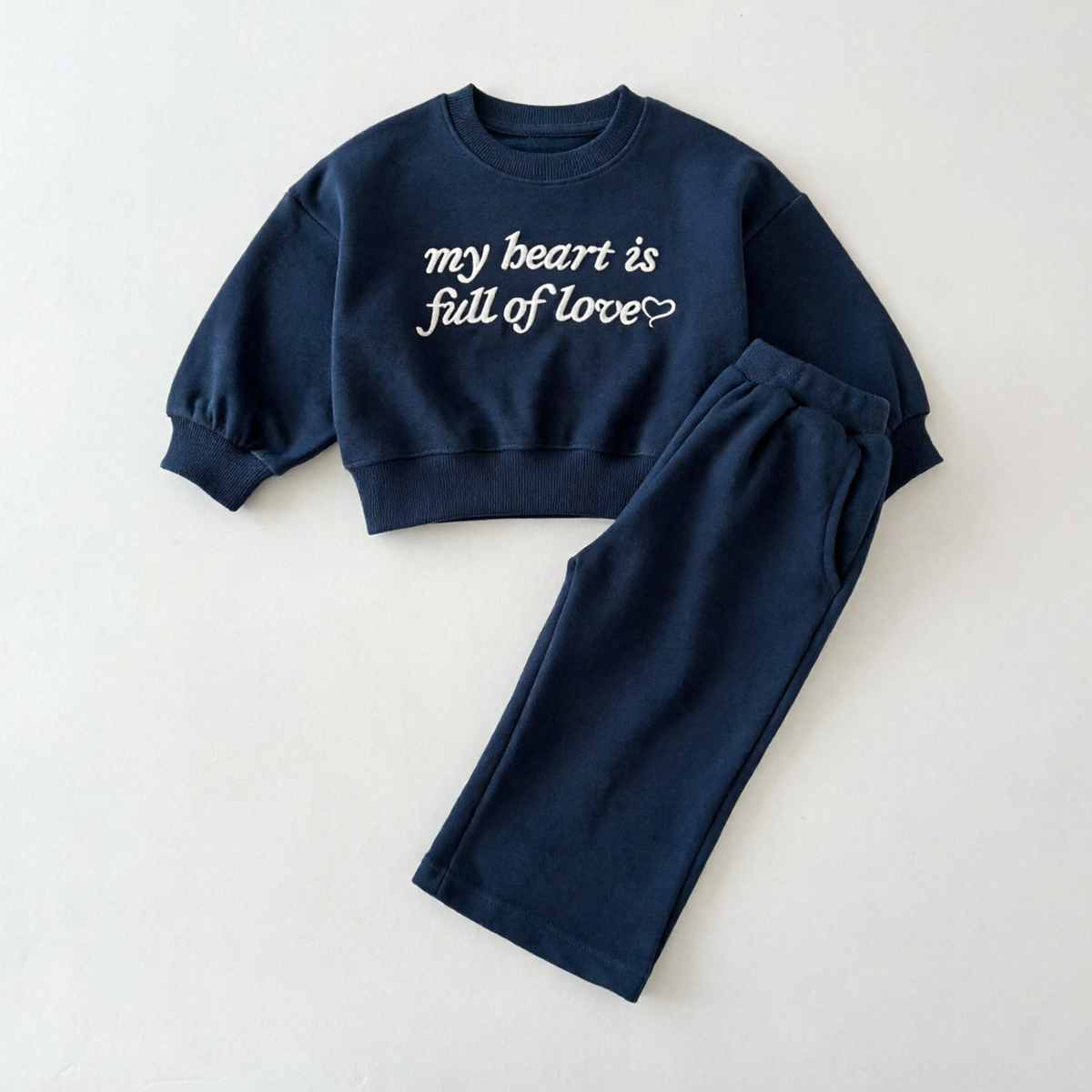 Marineblauwe sweater met witte geborduurde tekst en broek