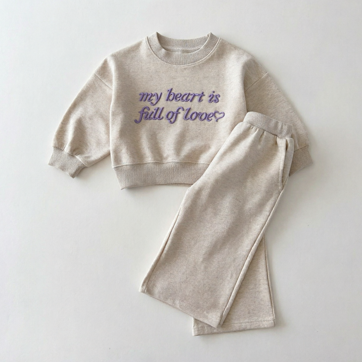 Lichtgrijze sweater met lila geborduurde tekst en wijde broek