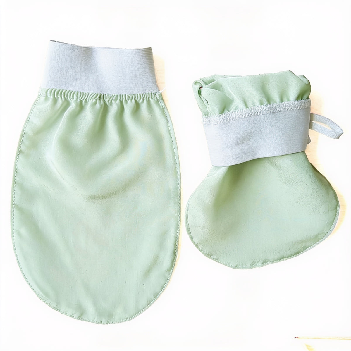 Two mint-green viscose wash gloves with white elastic cuffs, one larger and one smaller, on a white background