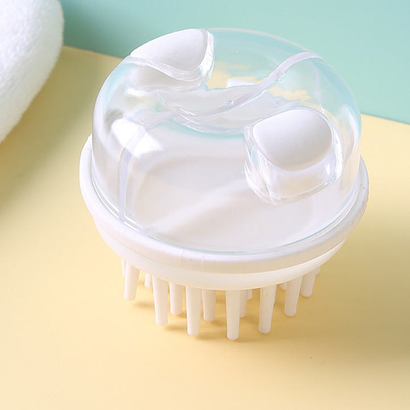 White shampoo brush with dispenser, top view showing the two white press buttons on the clear dome