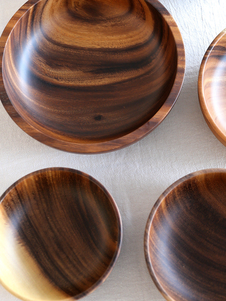 Close-up of four wooden bowls with dark grain arranged in a square pattern
