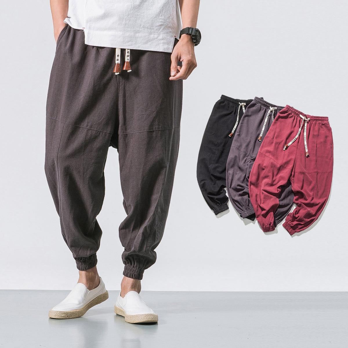 Grey relaxed drop-crotch joggers, worn by a model with white shoes, front view, casual setting