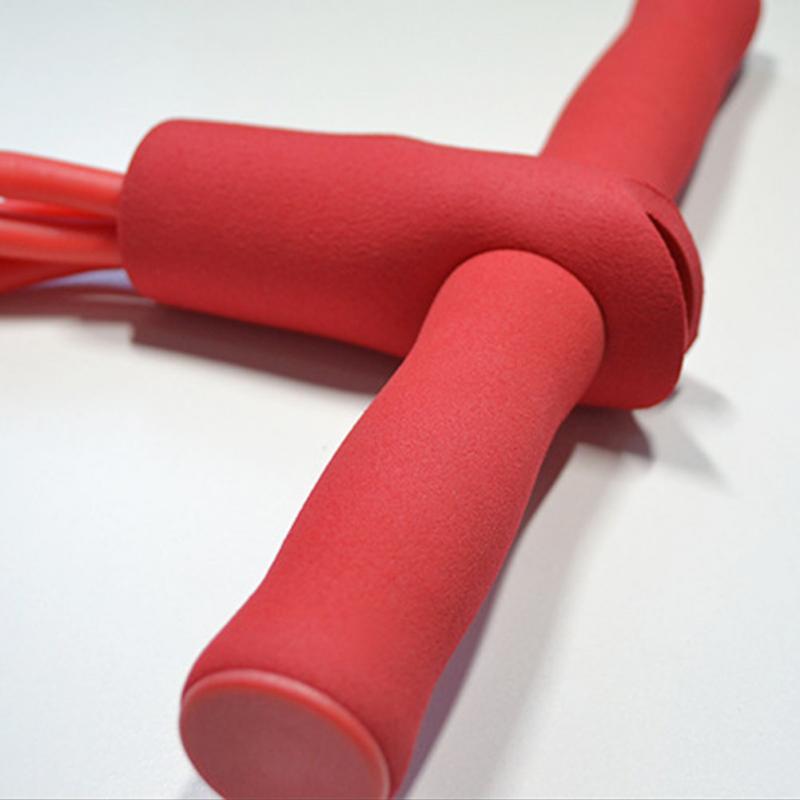 Close-up detail of red foot pedal resistance tube with padded foam grip
