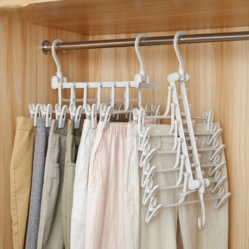 White 5-tier hanger with clips, multiple units in use, hanging pants on closet rod, side view
