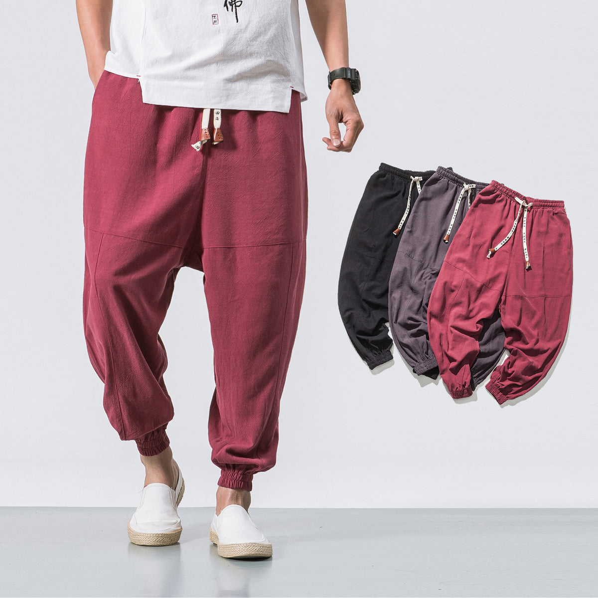 Wine red relaxed drop-crotch joggers, worn by a model with white shoes, front view, casual setting