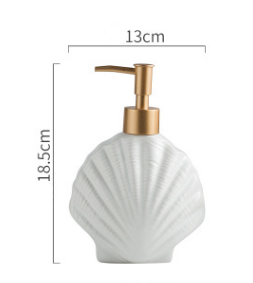 White ceramic shell soap dispenser with gold-tone pump top, front view with dimensions shown, isolated on white background