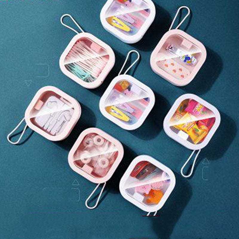 Compact flip-top storage case in pink and white, filled with toiletries, shown in a flat lay on a teal background