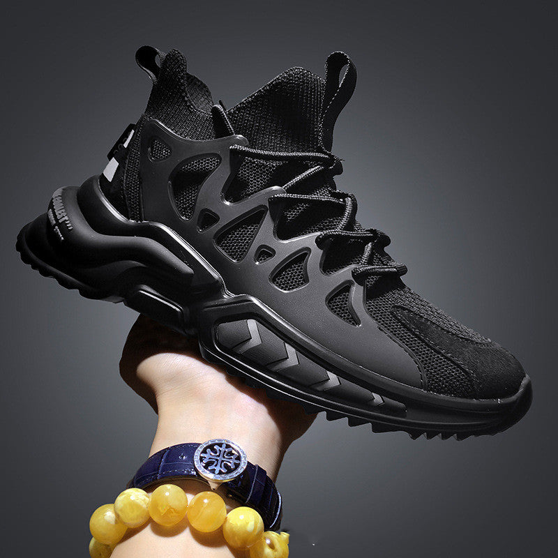 Men's knit sock-fit sneakers in black, side view held in hand against dark background