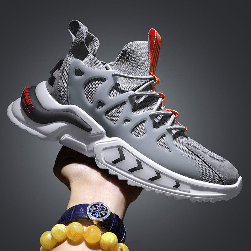 Men's knit sock-fit sneakers in grey with orange laces, side view held in hand against dark background