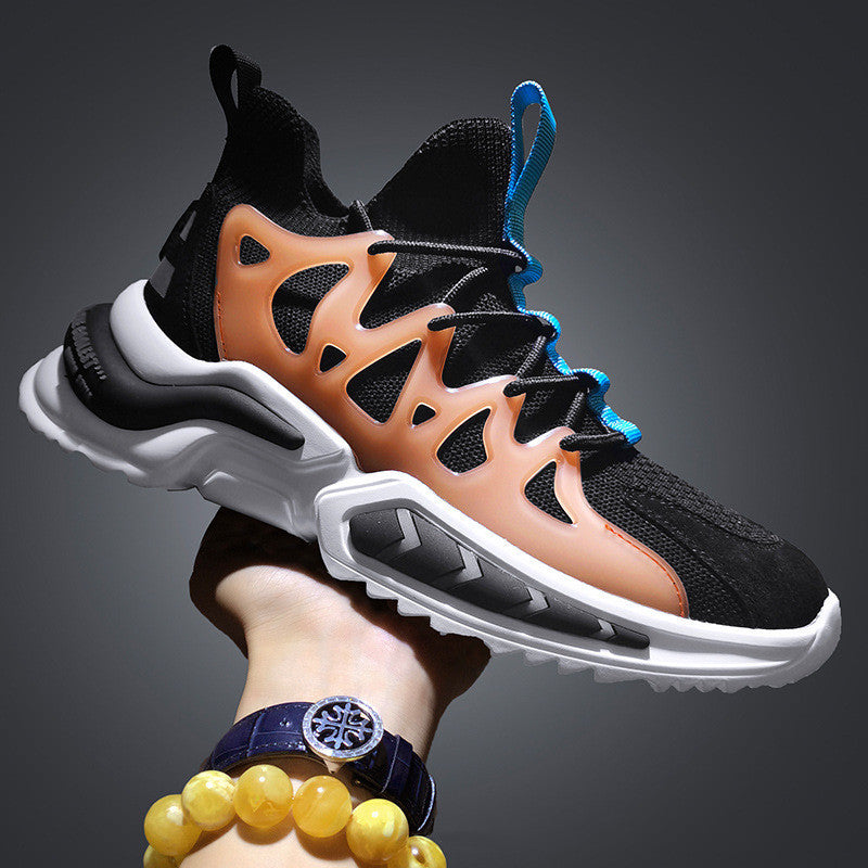 Men's knit sock-fit sneakers in black and orange with blue laces, side view held in hand against dark background
