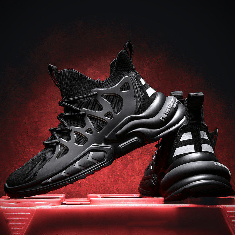 Men's knit sock-fit sneakers in black with white stripes, pair displayed on red platform against red backdrop