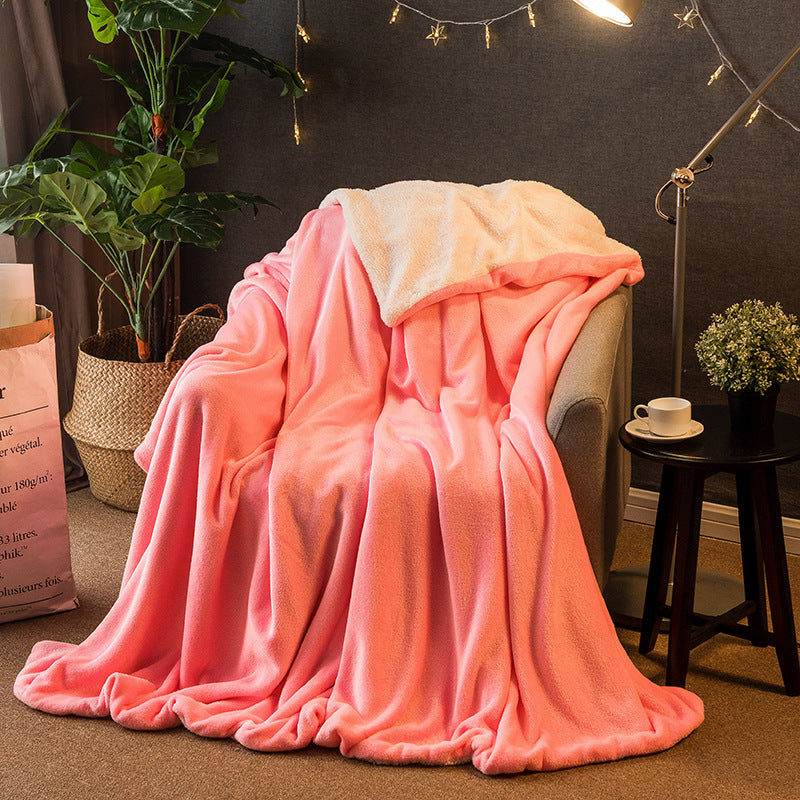 Reversible flannel throw in coral pink with cream sherpa lining, draped over armchair in living room setting