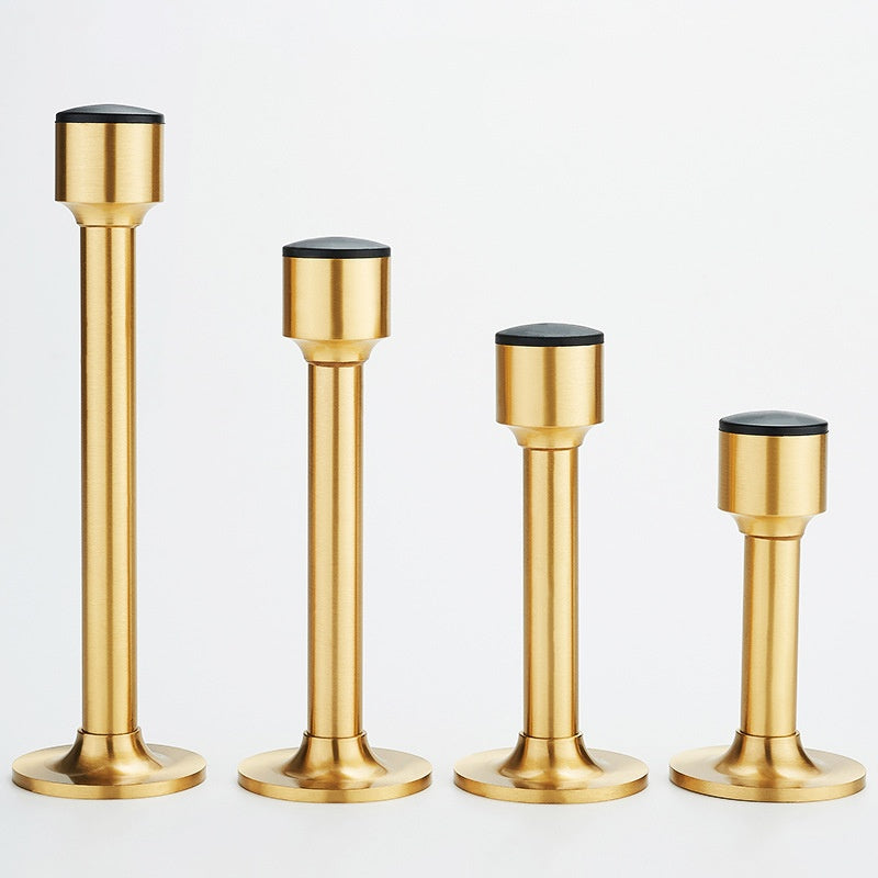 Brass-tone door stoppers with black rubber caps, four sizes in a row, front view, white background
