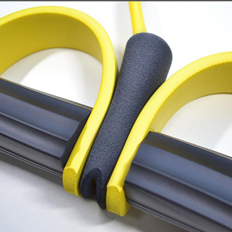 Close-up detail of yellow foot pedal resistance tube with padded foam grip