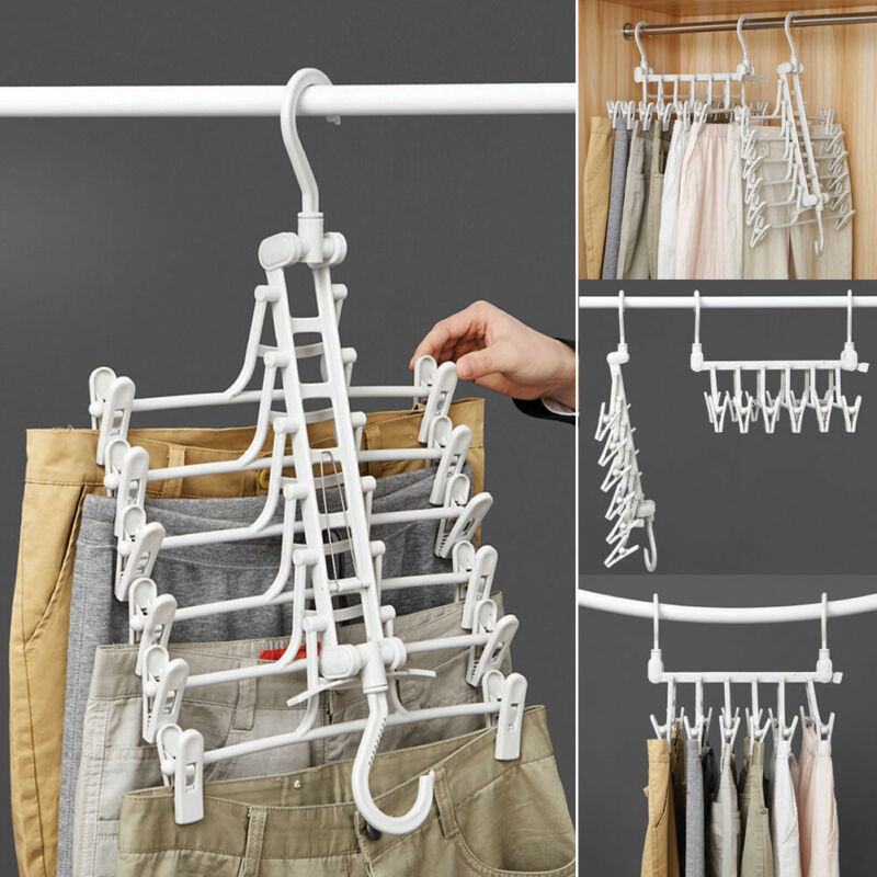 White foldable 5-tier hanger with clips, holding multiple pants, in use on a closet rod, front view