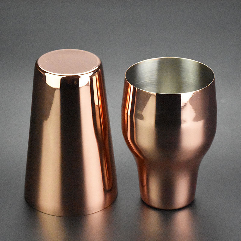 Two-section stainless steel cocktail shaker, 650 ml, rose gold finish, one upright and one inverted, side view, flat lay on