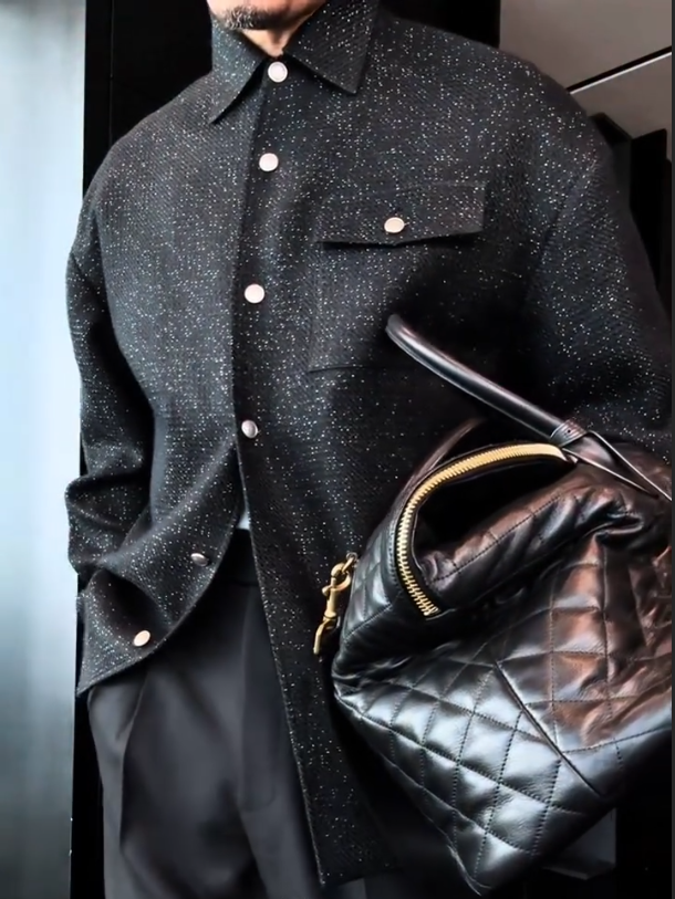 Snap-button overshirt jacket in black with fine flecked fabric and subtle sparkle, front view on model, chest pocket with