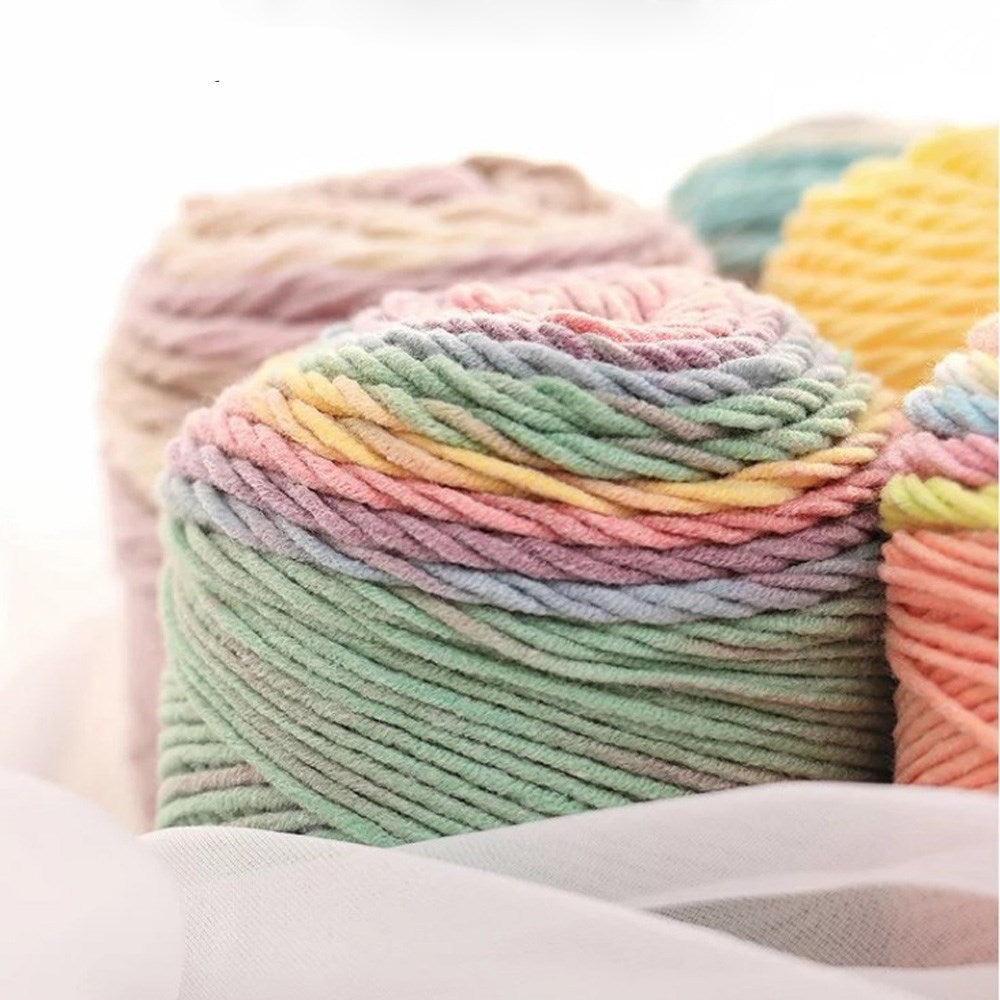 Close-up of gradient cotton-blend knitting yarn balls with pastel multicolour strands