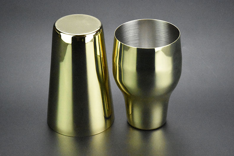 Two-section stainless steel cocktail shaker, 650 ml, gold-tone finish, one upright and one inverted, side view, flat lay on