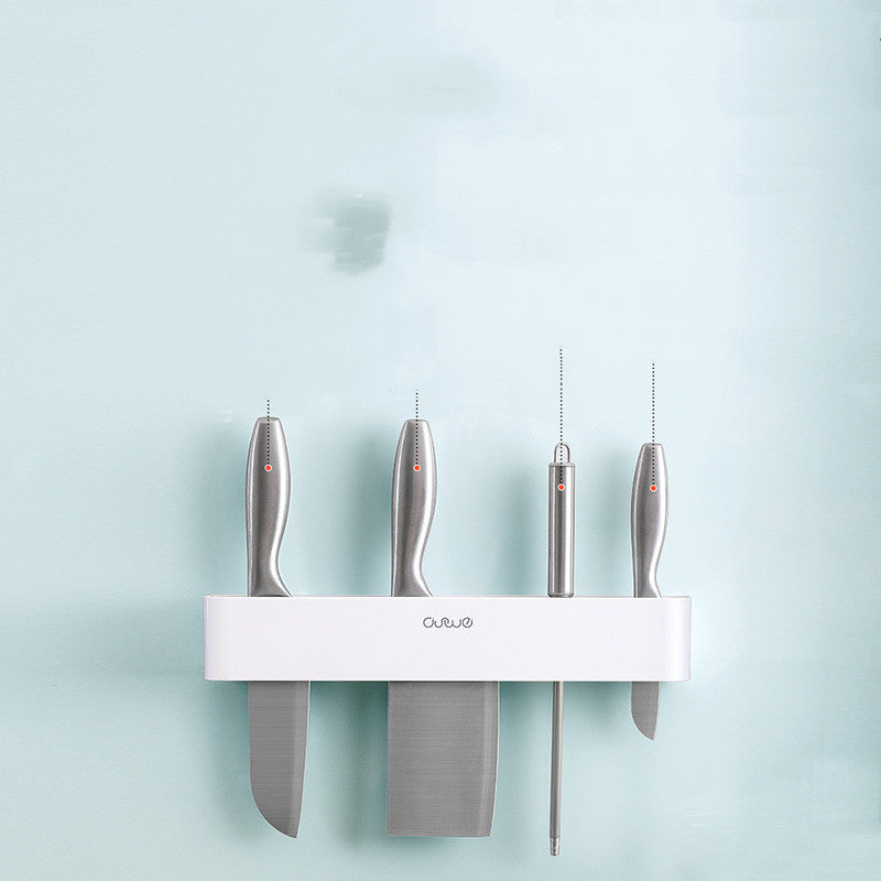 Wall-mounted magnetic knife bar with hooks, white, top-down view with four knives inserted against light blue background