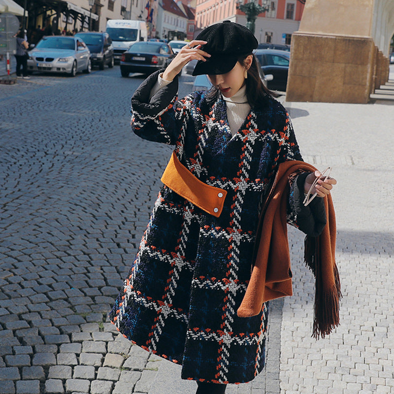 Front view of the oversized navy check cocoon coat, model adjusting her cap