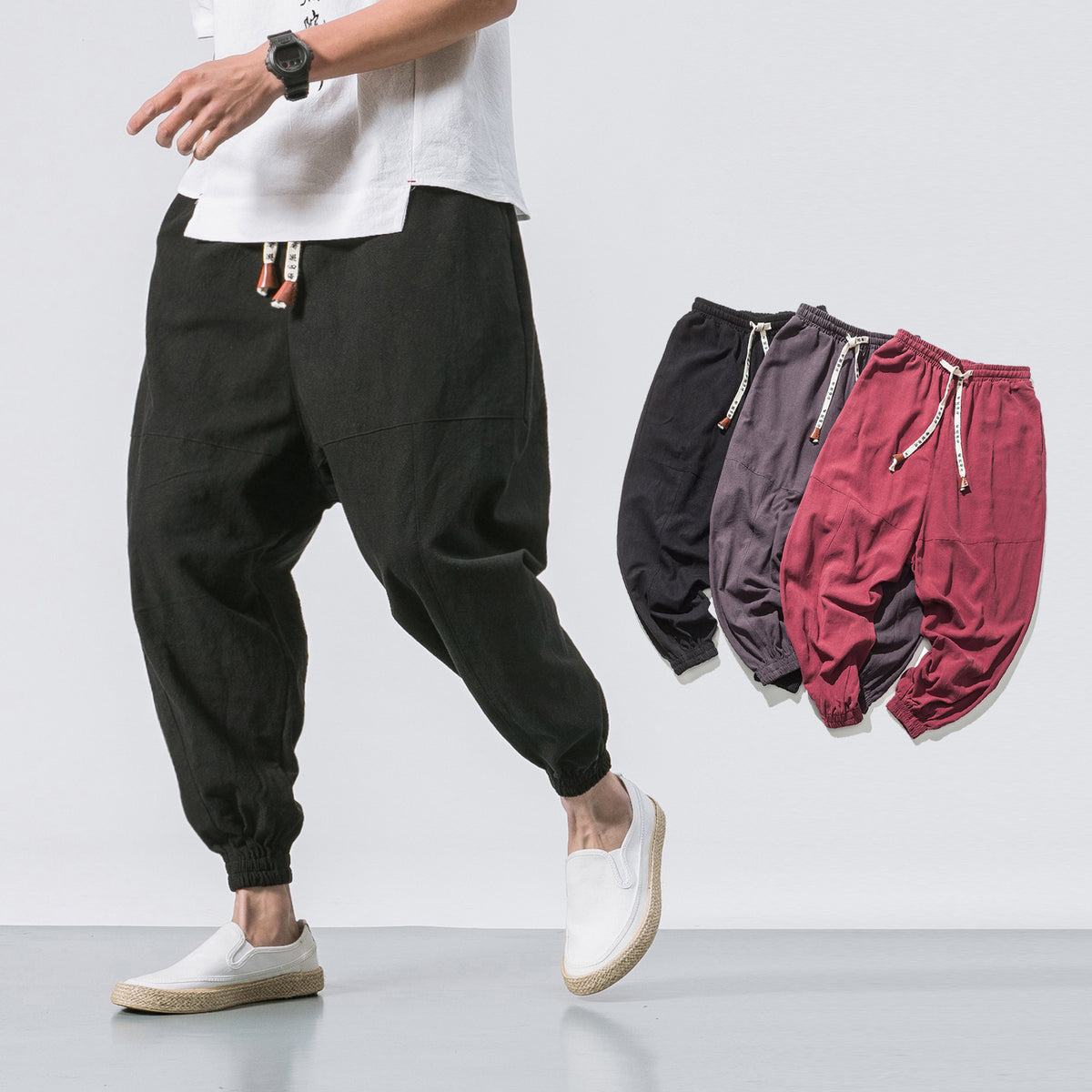 Relaxed drop-crotch joggers in black, worn by a model with white shoes, front view, casual setting