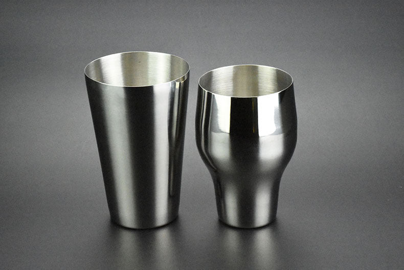 Two-section stainless steel cocktail shaker, 650 ml, silver finish, one upright and one inverted, side view, flat lay on