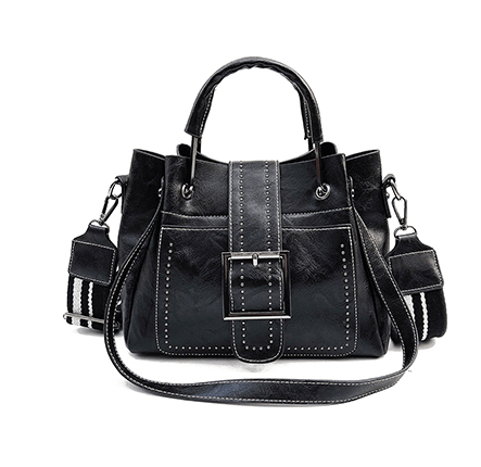 Black structured bucket-style handbag with front flap, large buckle, stud trim and detachable shoulder strap with striped pad