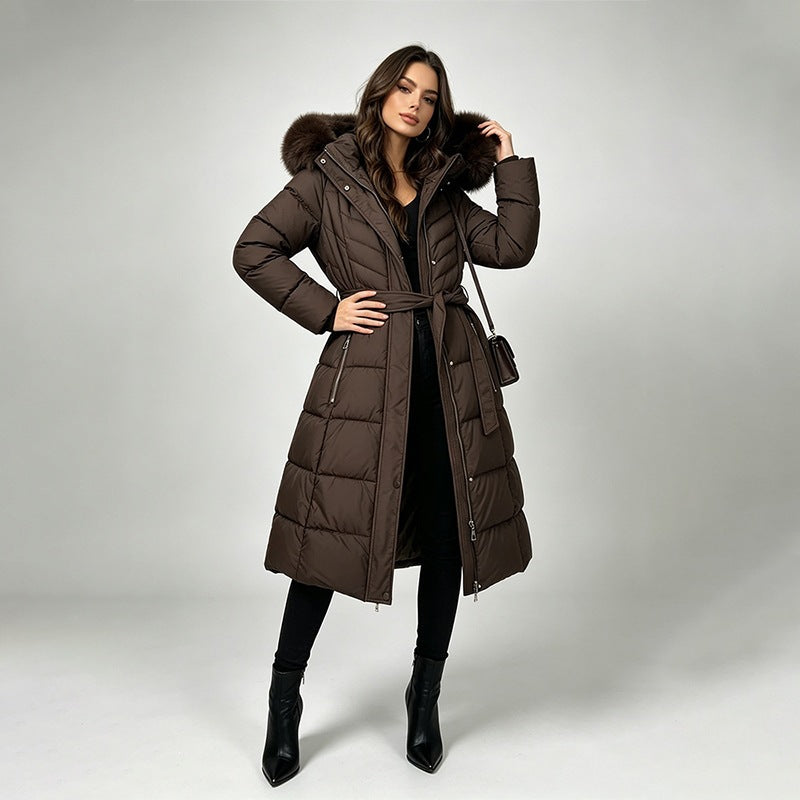 Long belted puffer coat with fur-look hood trim in coffee brown, front view on model, knee-length, side pockets, self-fabric