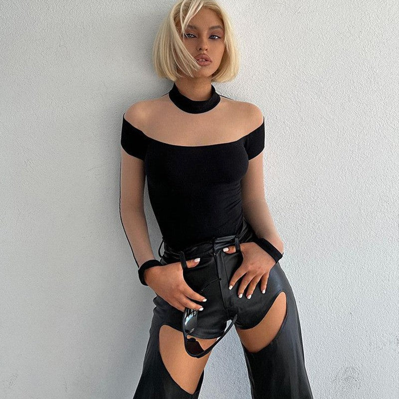 Model wearing the black sheer mesh mock-neck bodysuit with black faux-leather chaps, front view