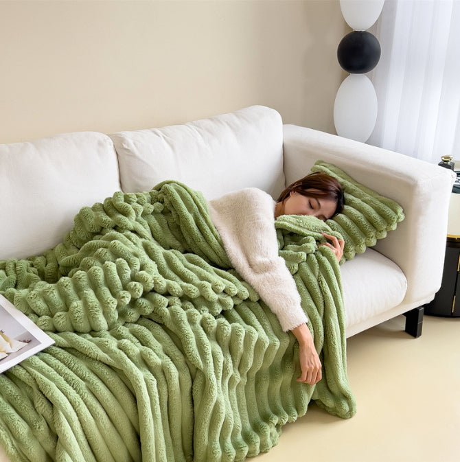 Light green ribbed throw draped over a white sofa