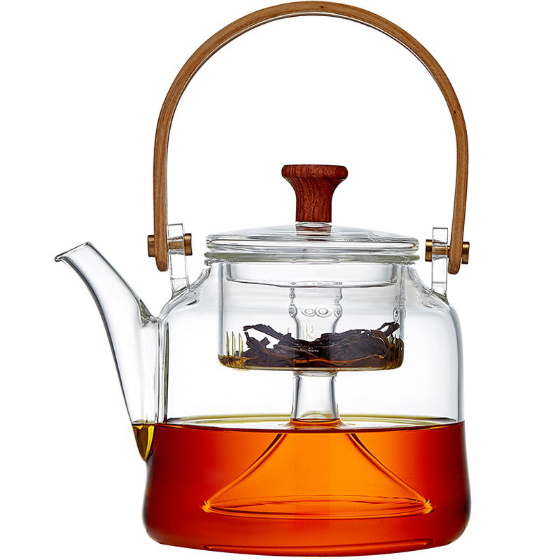 Glass teapot with wooden handle and lid knob, front view, filled with tea and visible infuser, white background