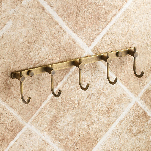 5-hook wall rail in antique brass-tone finish, mounted on tiled wall, no items hanging