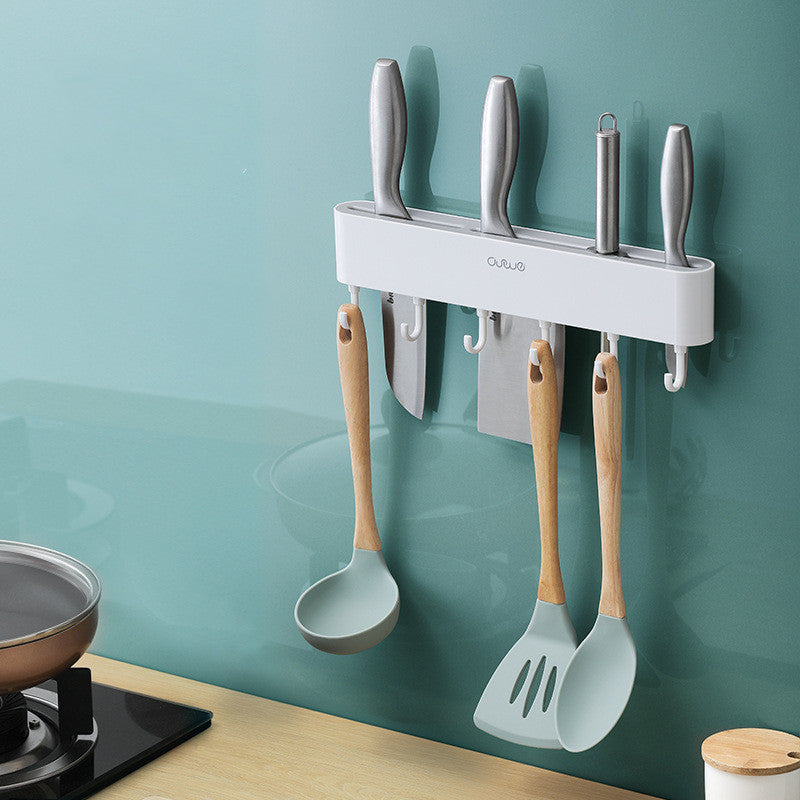 Wall-mounted magnetic knife bar with hooks, white, holding knives and utensils, front view in kitchen setting