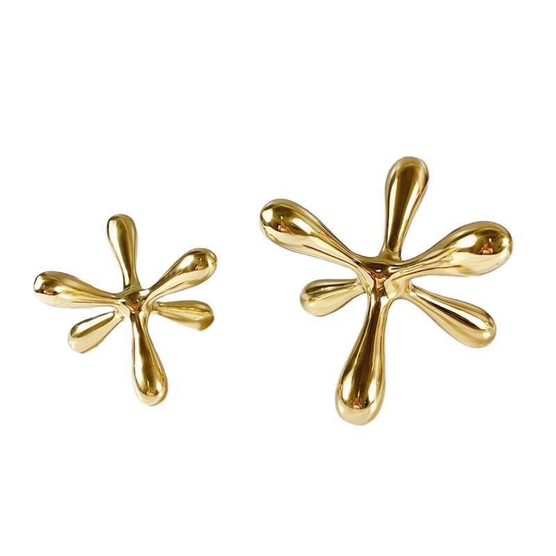 Gold-tone metal jacks sculpture with six rounded arms, front view, on white background