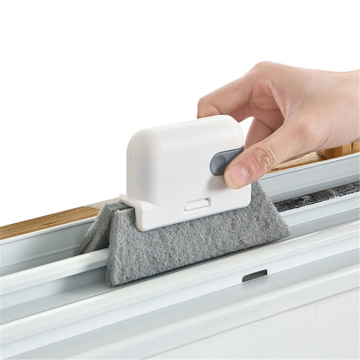 Detachable window and door track cleaning brush in white with grey pad, shown in use on a window track
