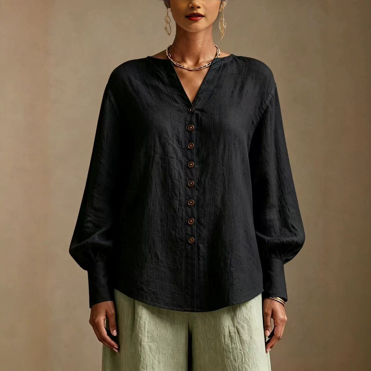 Black V-neck lantern-sleeve blouse with wood-tone buttons, front view on model