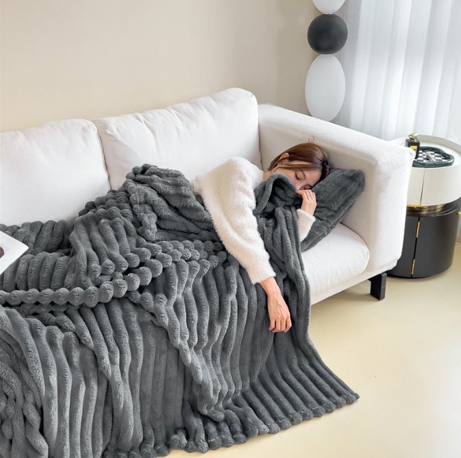 Dark Grey ribbed throw covering a person on a white sofa