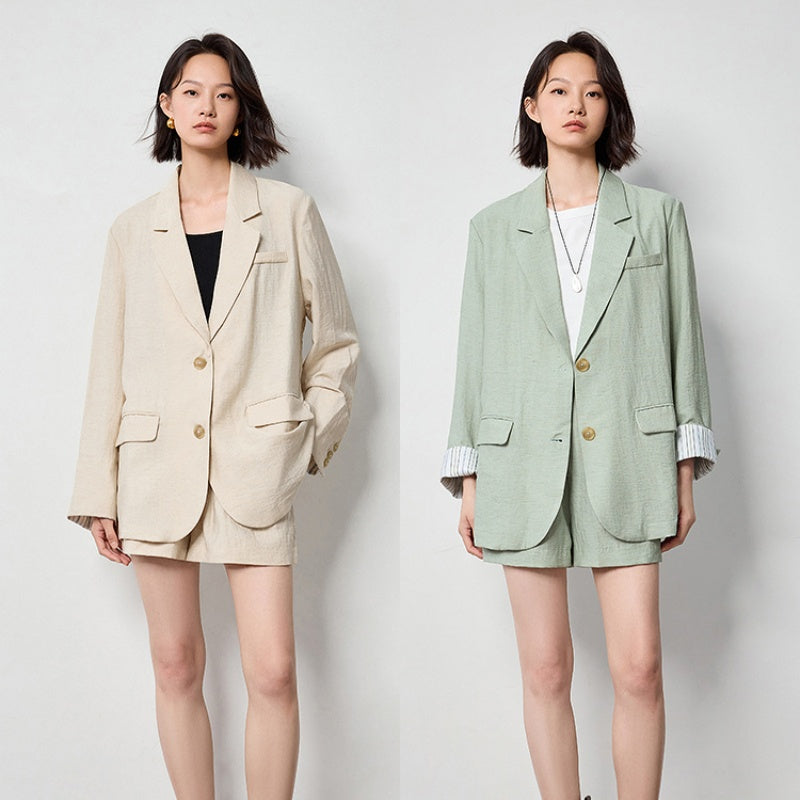 Two models wearing loose-fit linen-look blazers in beige and mint green, both with gold-tone buttons and turn-back cuffs