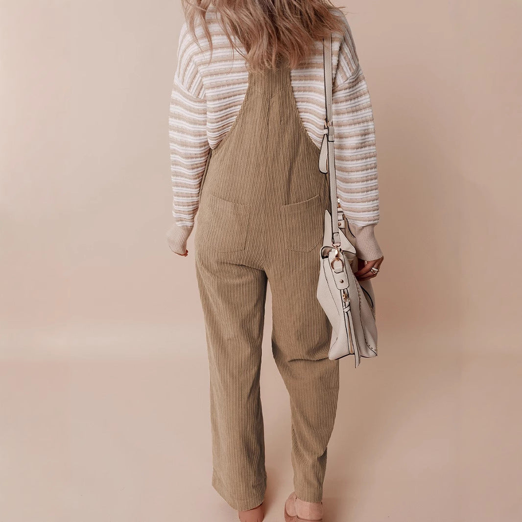 Back view of beige corduroy wide-leg dungarees with vertical stripes, worn with striped top and white shoulder bag