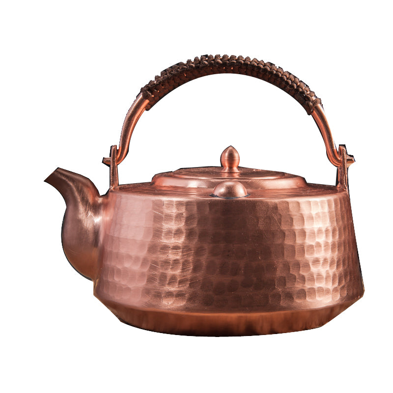 Front view of hammered copper teapot with top handle against white background