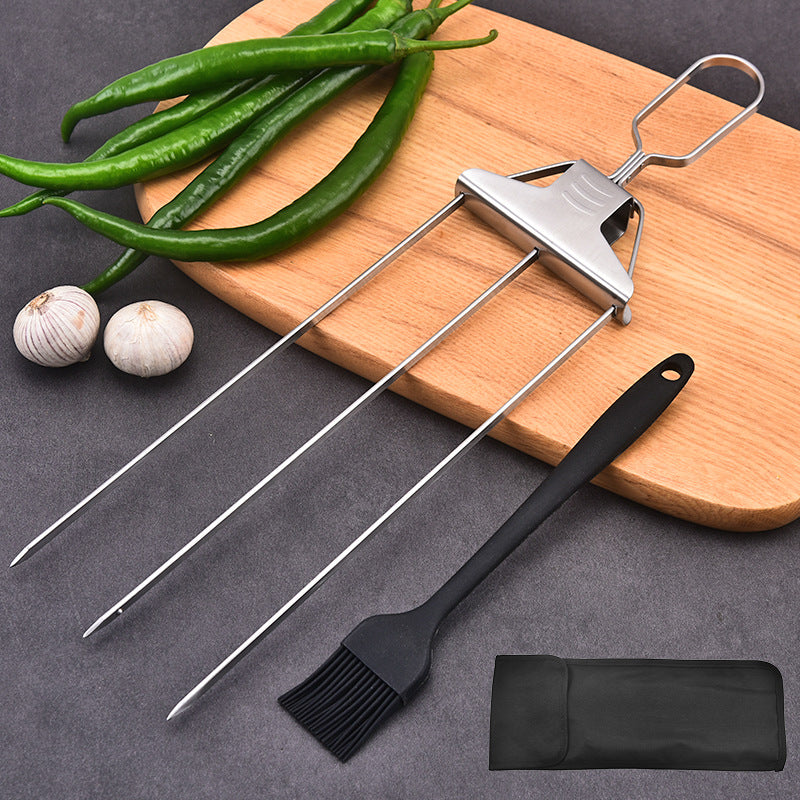 Three-prong stainless steel skewer with slide-off pusher, black silicone brush, and black fabric storage bag on a grey