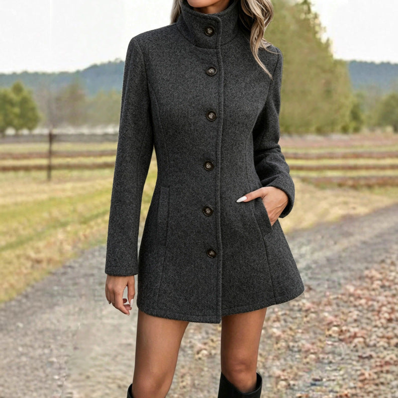 Fitted stand-collar coat in dark grey, single-breasted with button front, worn by model on gravel path