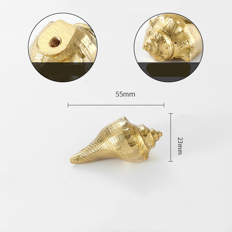 Gold-tone seashell cabinet knob, front view with detail of screw hole and side profile, flat lay on white background