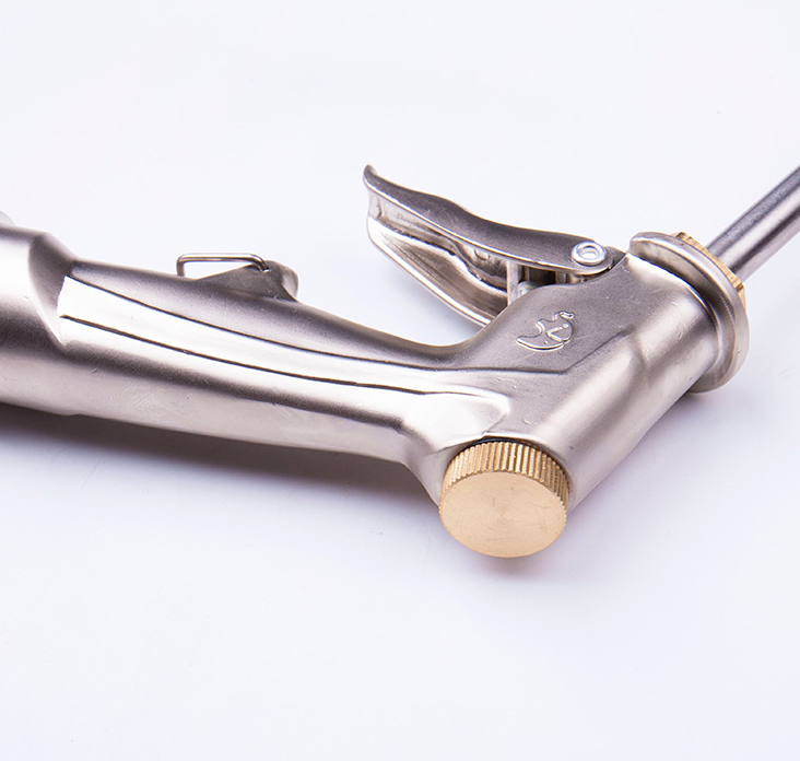 Side view of garden hose spray gun, showing brass-tone adjustment knob and trigger, silver body, white background