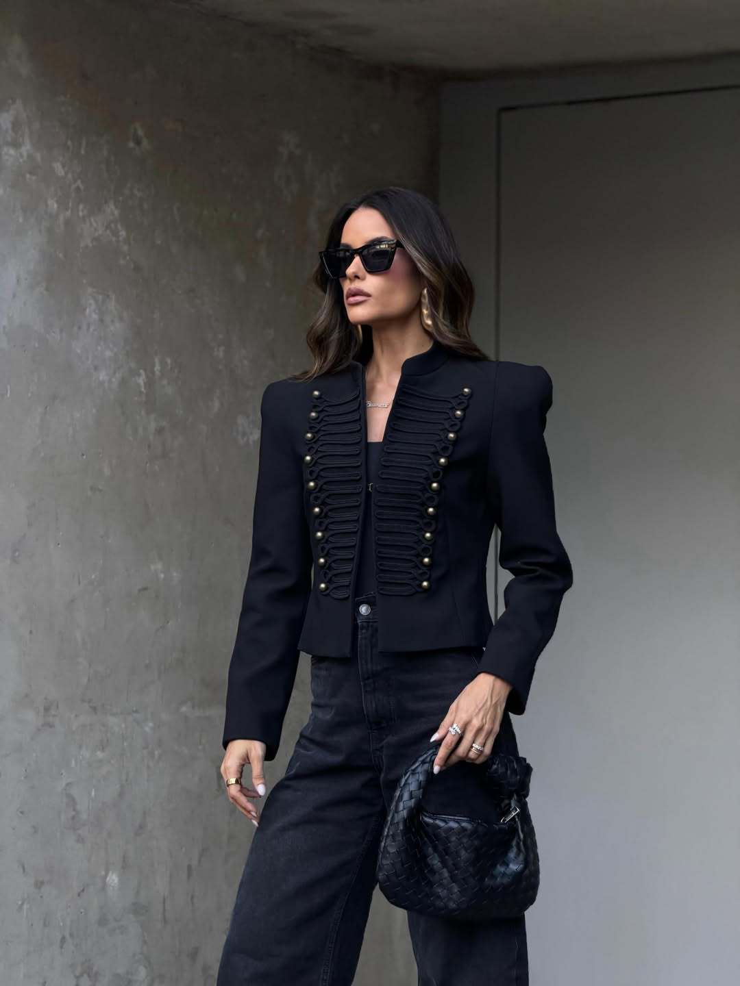 Black cropped blazer with braid trim and studs, front view from a slight angle