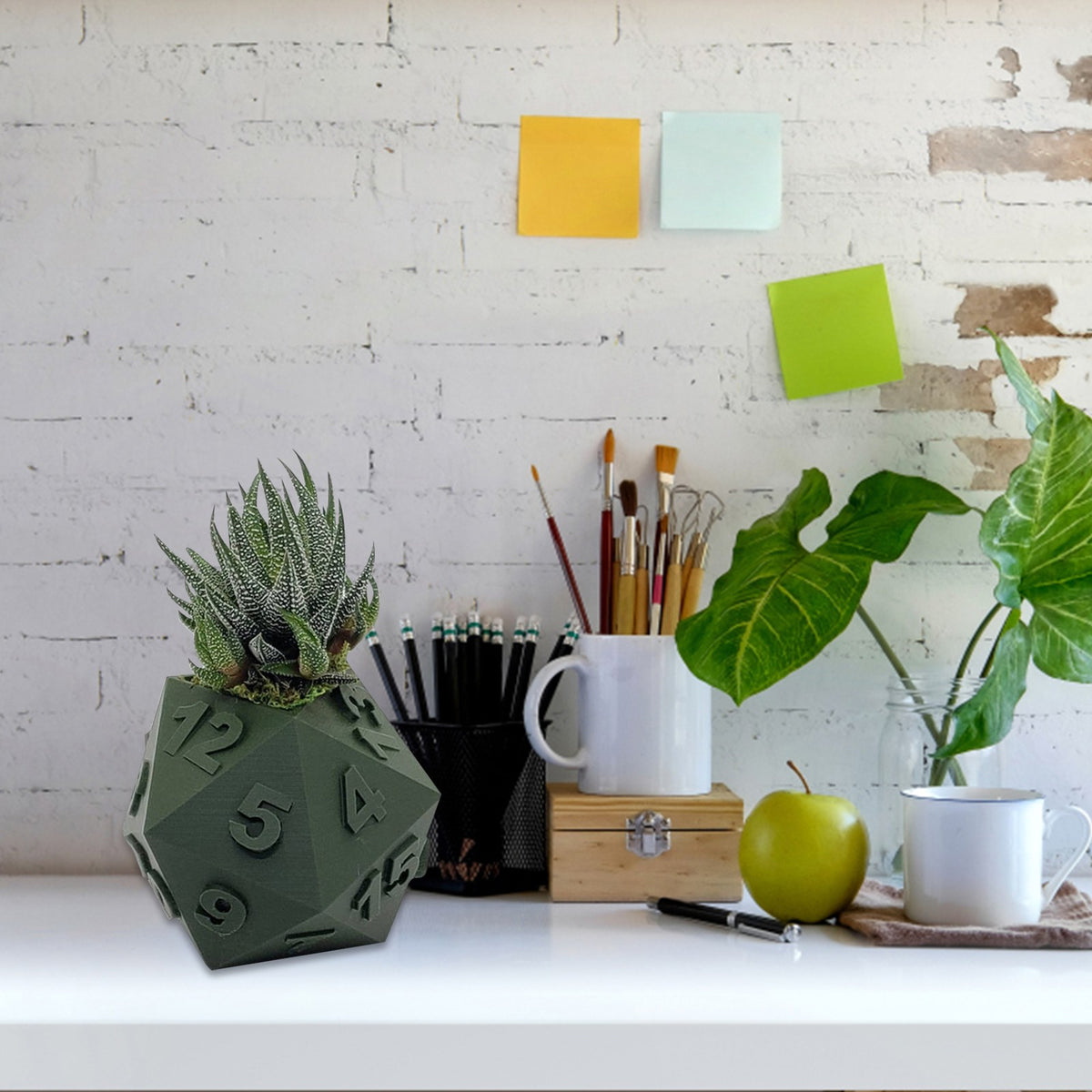 Multi-Sided Dice-Shape Succulent Planter in green, with numbers and succulent plant, on white desk with art supplies